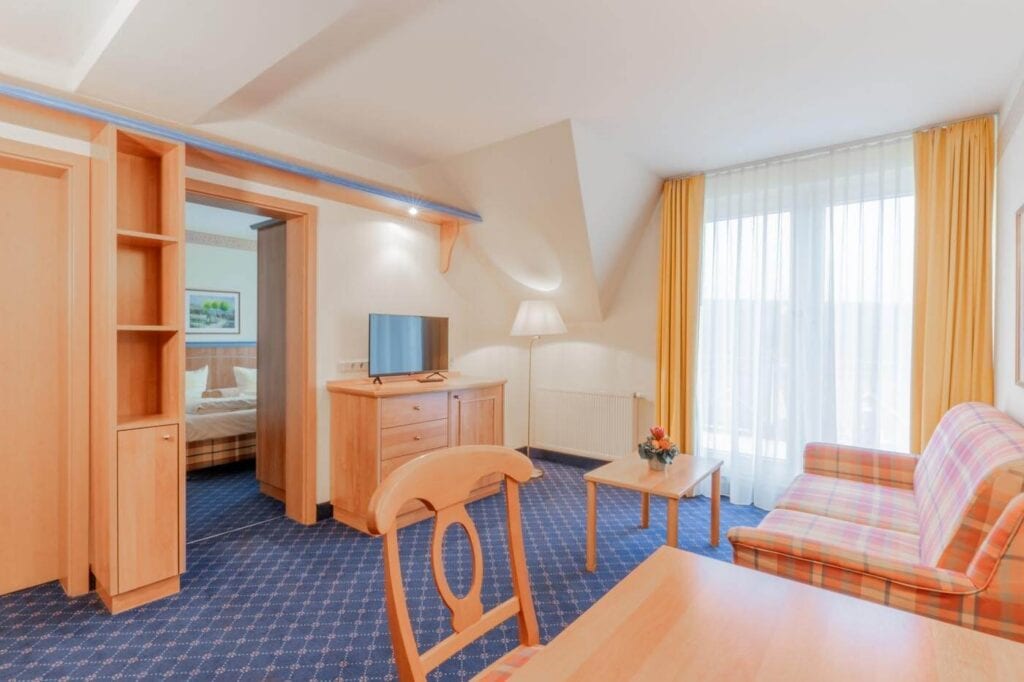 Wohnbereich mit Sofa, Sitzbereich und TV in warmen Farbtönen