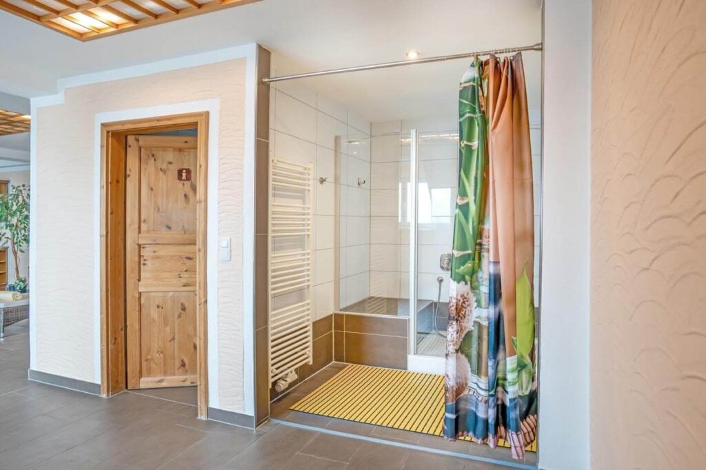 WC und Dusche mit Vorhang im Wellnessbereich