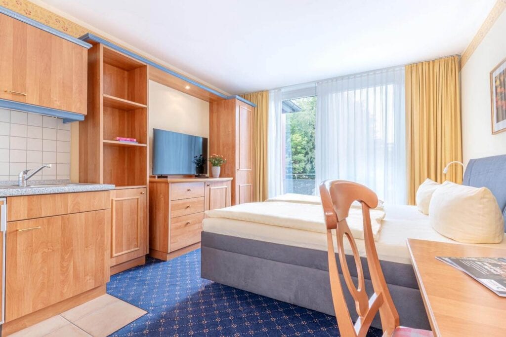 Ein-Zimmer-Studio mit Doppelbett, Küchenzeile, TV und großem Fenster